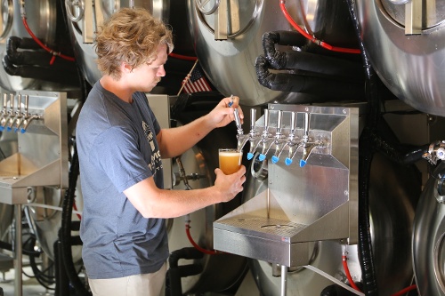 Neil pouring beer from Serving Beer Tanks